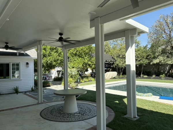 Covered patio with table and chairs under solid aluminum roof