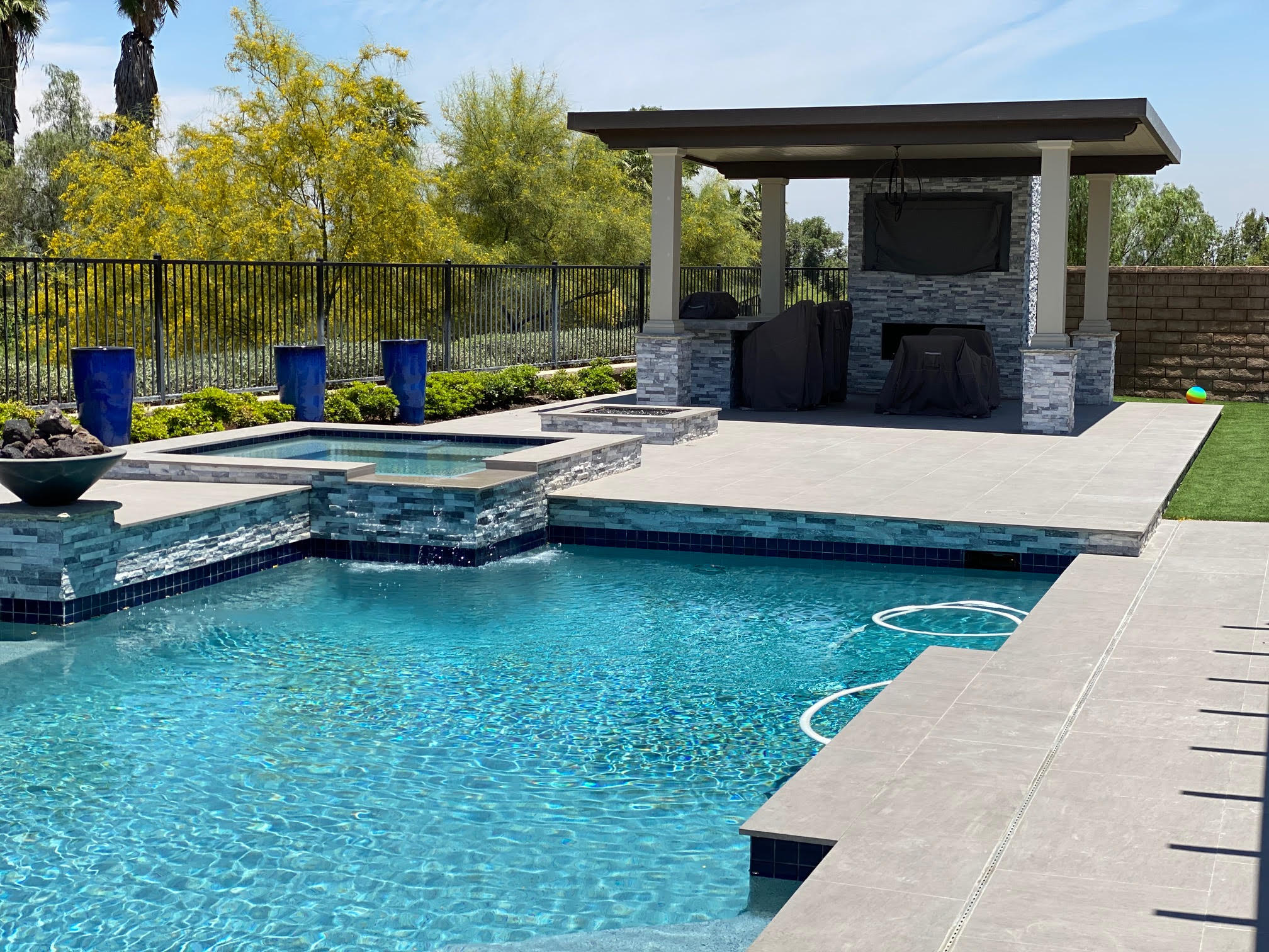 Completed aluminum patio cover installation on a brick house with outdoor furniture — Western Riverside County