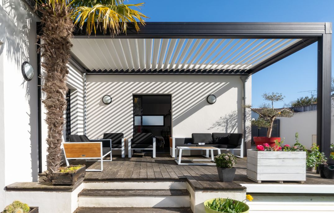White-roofed patio with wooden decking, featuring 4k Aluminum Patio Covers